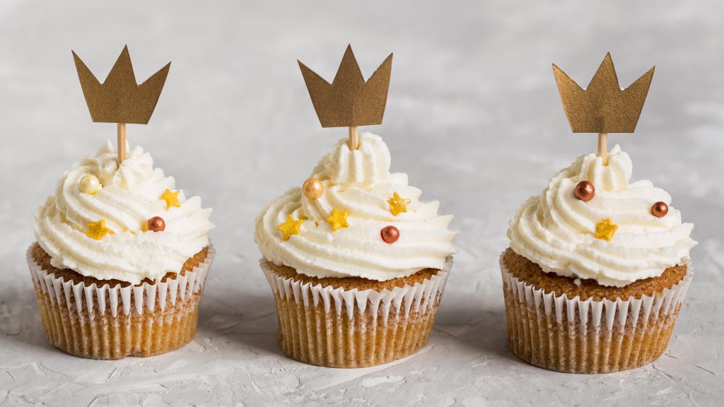 delicious cupcake wearing golden crowns